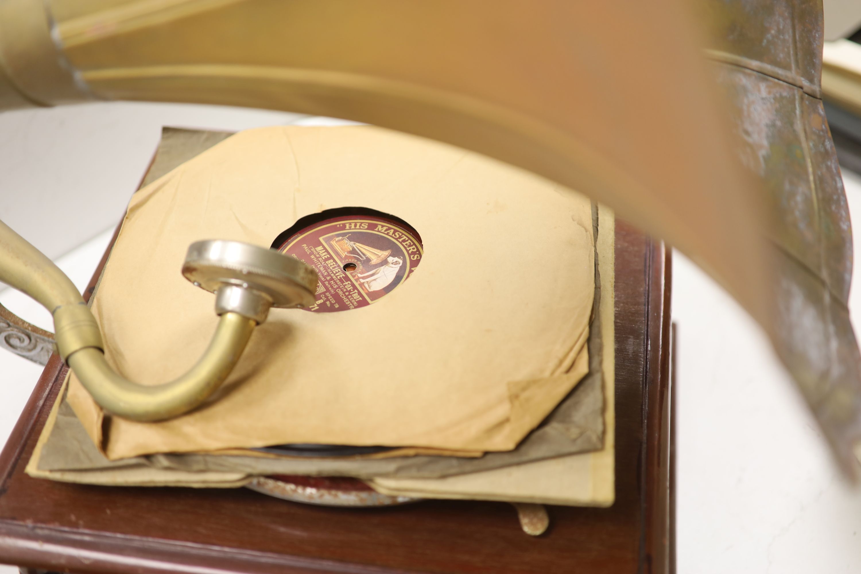 An HMV wind up gramophone with brass horn and three discs